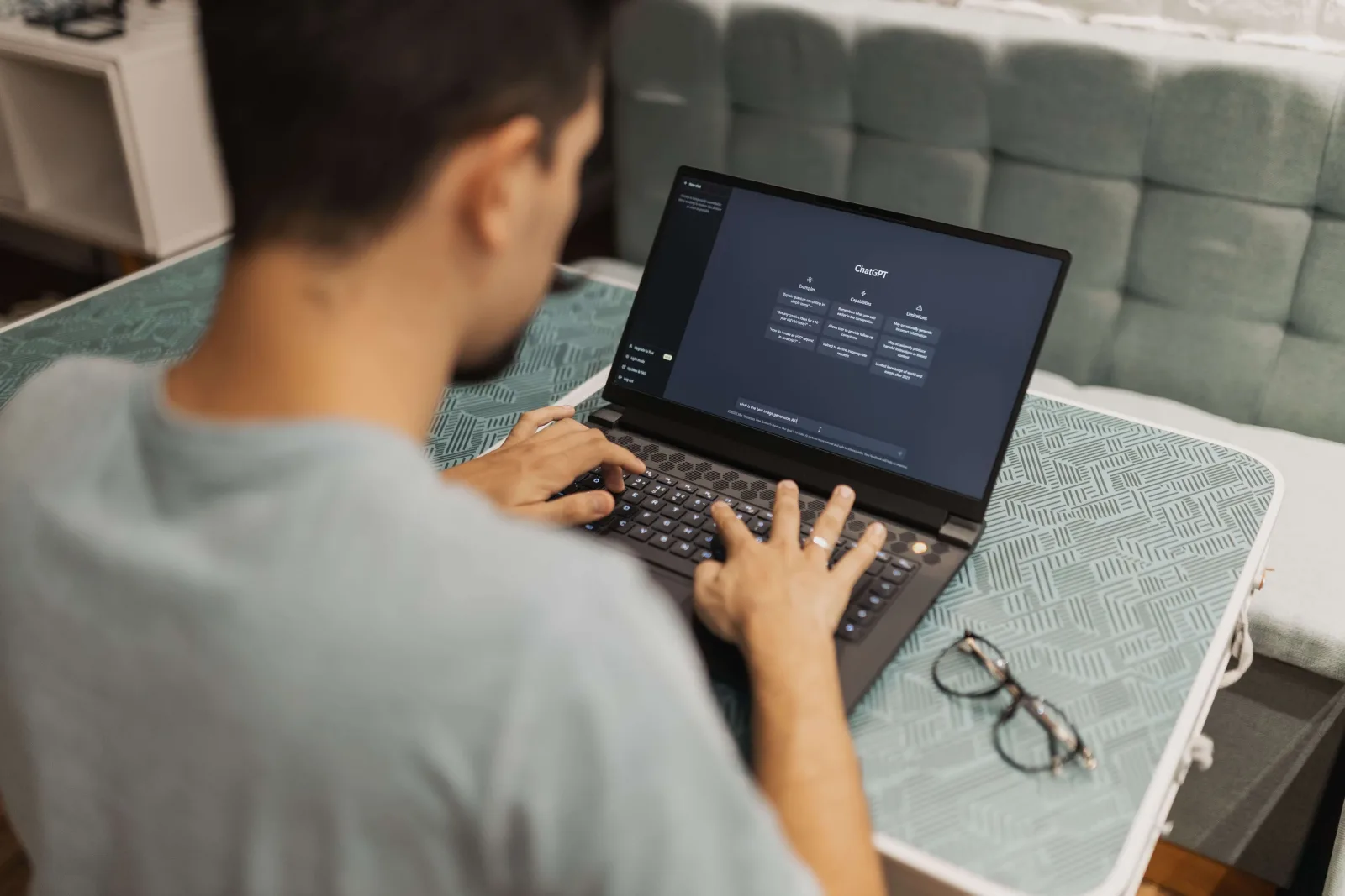 Egy ember laptopozik, a laptopj&aacute;n megnyitva a ChatGPT